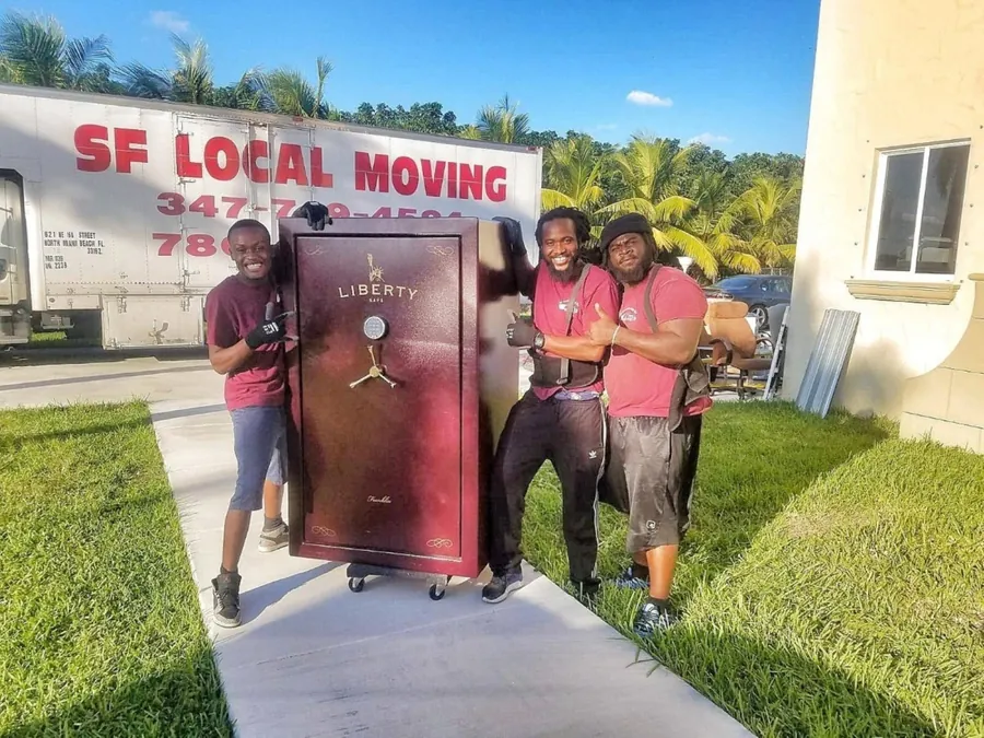 SF Local Moving crew in maroon shirts with a red gun safe in front of their truck
