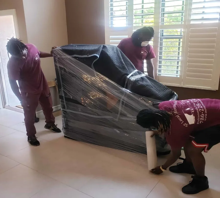 SF Local movers shrink-wrapping a black sofa