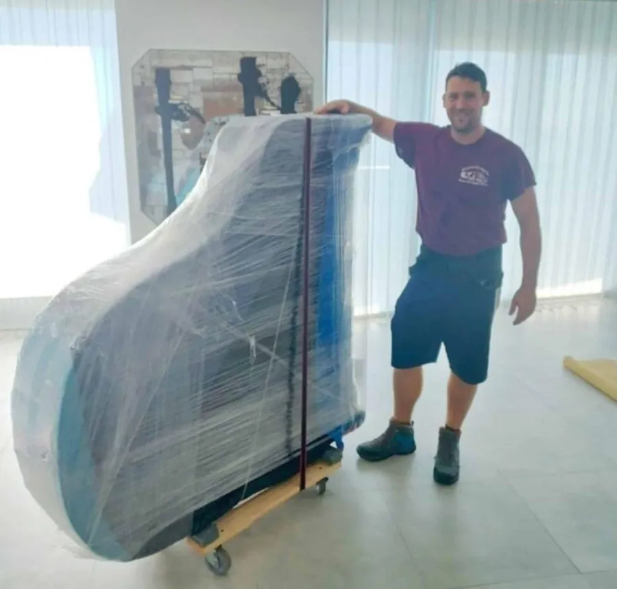 SF Local mover beside a shrink-wrapped grand piano on a piano board