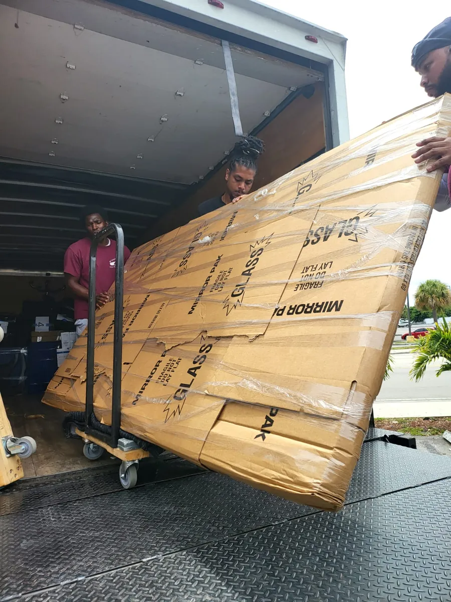 SF Local crew loading a large wrapped glass panel onto the truck lift gate