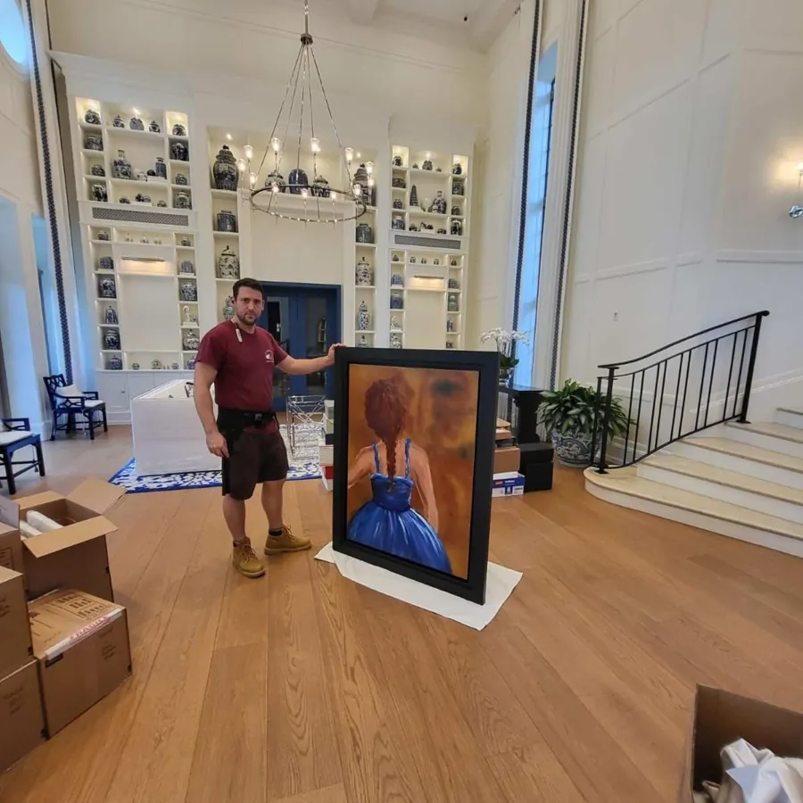 SF Local mover carrying a large framed painting in a grand living room